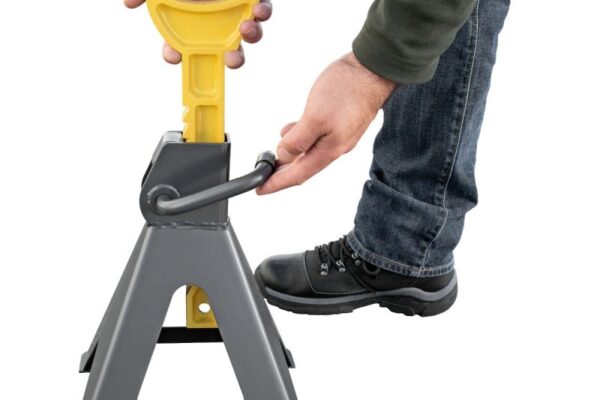 Mechanic using a car jack and jack stands safely to lift a vehicle for brake repair, tire change, or routine maintenance.